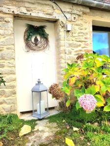 una puerta delantera de una casa con una linterna y flores en Gîte La Fontaine des Prés en Cherbourg en Cotentin