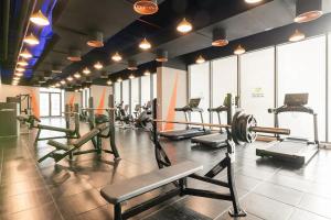 a gym with several treadms and machines in a room at Landing Lane Family Suites, Studio Near DXB Airport in Dubai