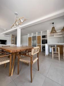 cocina y comedor con mesa de madera y sillas en Cortijo Cantalobos, en Almuñécar
