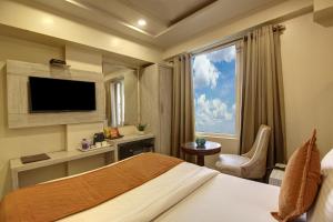 ニューデリーにあるHotel Shanti Plaza-by Haveliya Hotelsのベッドと大きな窓が備わるホテルルームです。