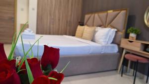 a bedroom with a bed with red flowers in the foreground at Landing Lane Family Suites, Studio Near DXB Airport in Dubai