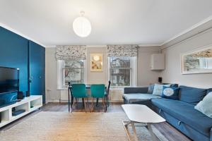 ロンドンにあるFlat 1 - 2 Bedrooms and Private Terraceのリビングルーム(青いソファ、テーブル付)