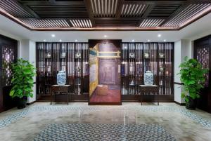 a lobby with a door with a statue on it at Wyndham Garden Hoi An Cua Dai Beach in Hoi An