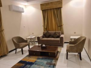 a living room with a couch and two chairs at Dshale Apartments in Taif