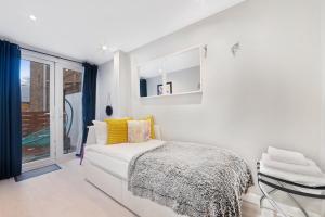 a white bedroom with a bed and a window at Flat 1 - 2 Bedrooms and Private Terrace in London