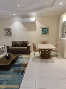 sala de estar con sofá y mesa en Dshale Apartments en Taif