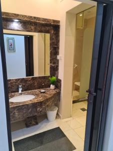 a bathroom with a sink and a mirror at Dshale Apartments in Taif