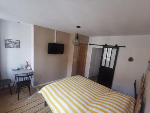 a bedroom with a bed and a table and a television at La chambre de pousse in Boulogne-sur-Mer
