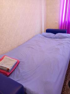 NIZAMI Street flat في باكو: سرير في غرفة نوم ومفرش ازرق ومنشفة