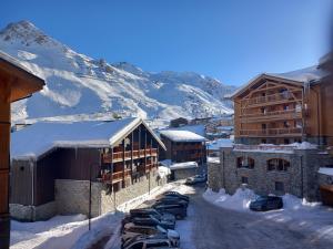 um grupo de carros estacionados num parque de estacionamento na neve em Luxueux appartement T4 skis aux pieds à Tignes le Lac em Tignes