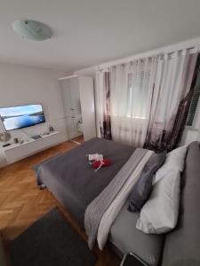 a bedroom with a large bed and a flat screen tv at Apartman Sweet penthouse self check-in in Karlovac