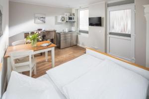 a small kitchen and dining room with a table and a bed at Haus Delft Agadir in Juist