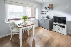a kitchen with a dining room table and a television at Haus Delft Minerva in Juist
