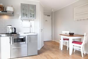 a kitchen with a sink and a table with chairs at Haus Delft Nordstern in Juist