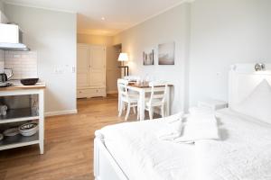 a bedroom with a white bed and a table with chairs at Haus Delft Jakea in Juist