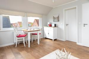 a kitchen with a table and chairs in a room at Haus Delft Baoule in Juist
