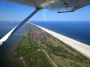 an aerial view of an island in the ocean at Haus Delft Baoule in Juist +6 photos