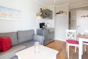 a living room with a couch and a kitchen at Haus Delft Elisa in Juist