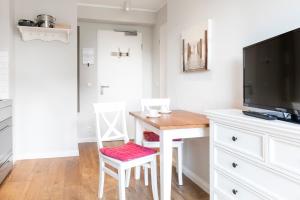 a living room with a desk and a tv at Haus Delft Elisa in Juist +6 photos