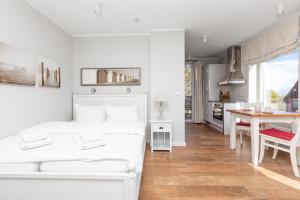 a white bedroom with a bed and a table at Haus Delft Lita in Juist