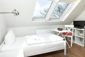 a living room with a white couch and a window at Haus Delft Ilmenau in Juist