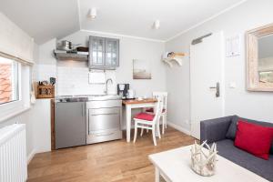 a kitchen and living room with a couch and a table at Haus Delft Angelino in Juist +6 photos