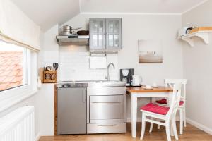 a small kitchen with a sink and a table at Haus Delft Angelino in Juist