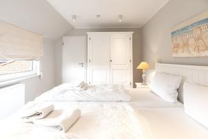 a bedroom with a white bed with towels on it at Haus Delft Angelino in Juist