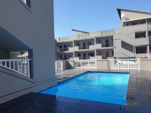 a swimming pool in front of a building at The Spot on the Beach in Kingsburgh +18 photos