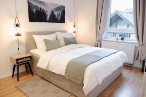 Un dormitorio con una cama grande y una ventana en JASTA Homes: Altstadt-Apartment en Hameln