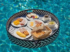a tray of breakfast food on a table next to a pool at R1 Resort Rajapruek Chiangmai in Chiang Mai