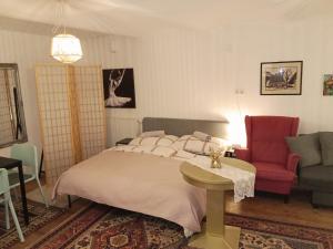 a bedroom with a bed and a red chair at Studio in Altstadthaus in Sankt Veit an der Glan