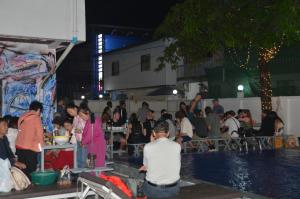 una multitud de personas sentadas alrededor de una piscina en una fiesta en Vientiane Garden Hostel en Vientián
