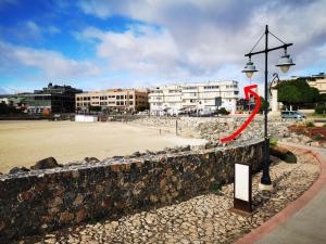 a street light with a red arrow pointing towards a beach at 2V LUXURY APARTMENT NEAR BEACH in Puerto del Rosario