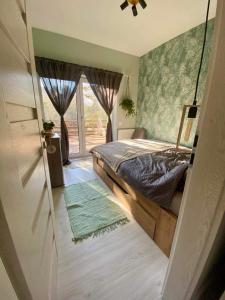 1 dormitorio con 1 cama y puerta corredera de cristal en Zebikuckó, en Zebegény