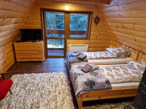 1 dormitorio con 2 camas en una cabaña de madera en Dacza Zakątek en Falsztyn