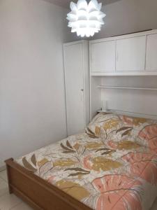 een slaapkamer met een bed in een kamer met een kroonluchter bij Beau T3 face Rouet plage avec garage in Carry-le-Rouet