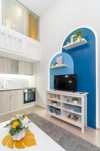 een woonkamer met een tv en een blauwe muur bij Déja Blue Old City Center studio. in Sofia