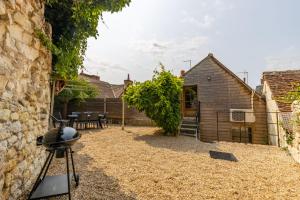 a backyard with a barbecue grill and a building at La Belle Grace in Saint-Aignan