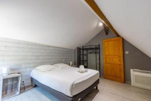 a bedroom with a white bed in a attic at La Belle Grace in Saint-Aignan