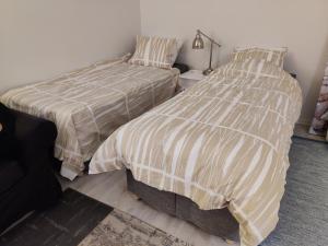two beds sitting next to each other in a bedroom at Studio Porin Oksi, home away home in Pori city center, free parking in Pori