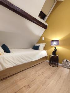 1 dormitorio con 2 camas y una lámpara en el suelo de madera en La Maison Flore ! Confort et Nature, en Flexbourg