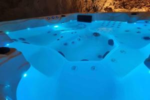 Parnay的住宿－Gîte 21 route de saumur，洞穴内带蓝色灯光的按摩浴缸