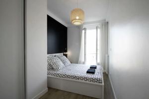 a white bedroom with a bed with a window at Magnifique 3 pièces Garibaldi in Nice