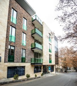 um edifício de apartamentos com varandas numa rua em Brosse Garden em Tbilisi