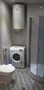 Un baño con lavadora y un inodoro. en ApartHotel Calypso in Orbi, en Batumi 22 fotos más