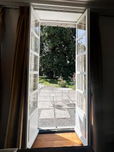 an open door with a view of a yard at La Maison Gavraise in Gavray