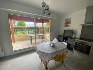 uma cozinha com uma mesa e uma sala de jantar com um pátio em Le Petit Nid du Port Crouesty - Studio au calme em Arzon