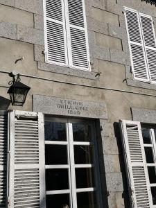 un edificio con un cartel sobre una puerta con ventanas en La Maison Gavraise, en Gavray