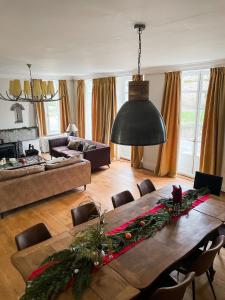 a living room with a wooden table with christmas decorations at La Maison Gavraise in Gavray